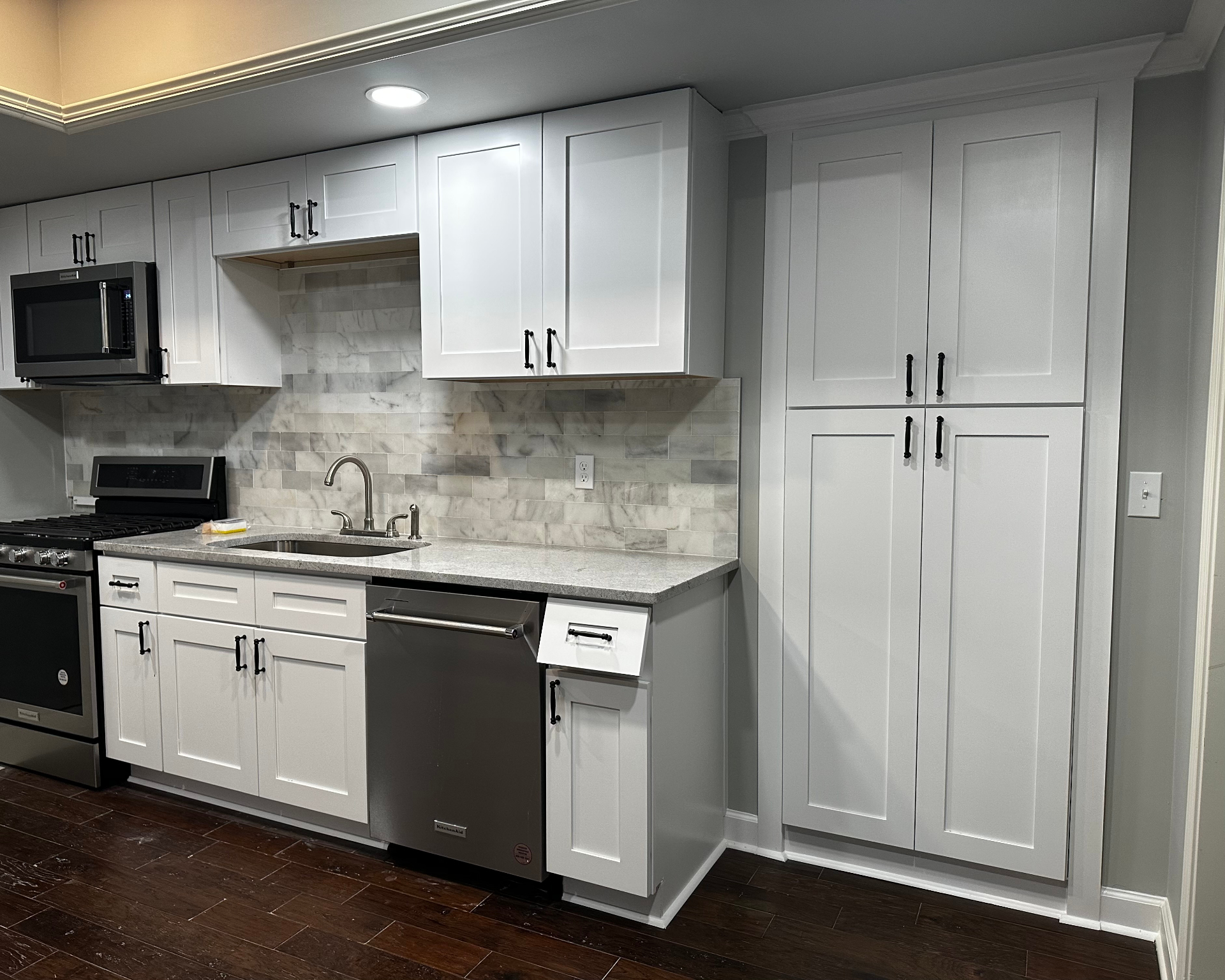 Custom cabinetry and marble backsplash in remodeled kitchen