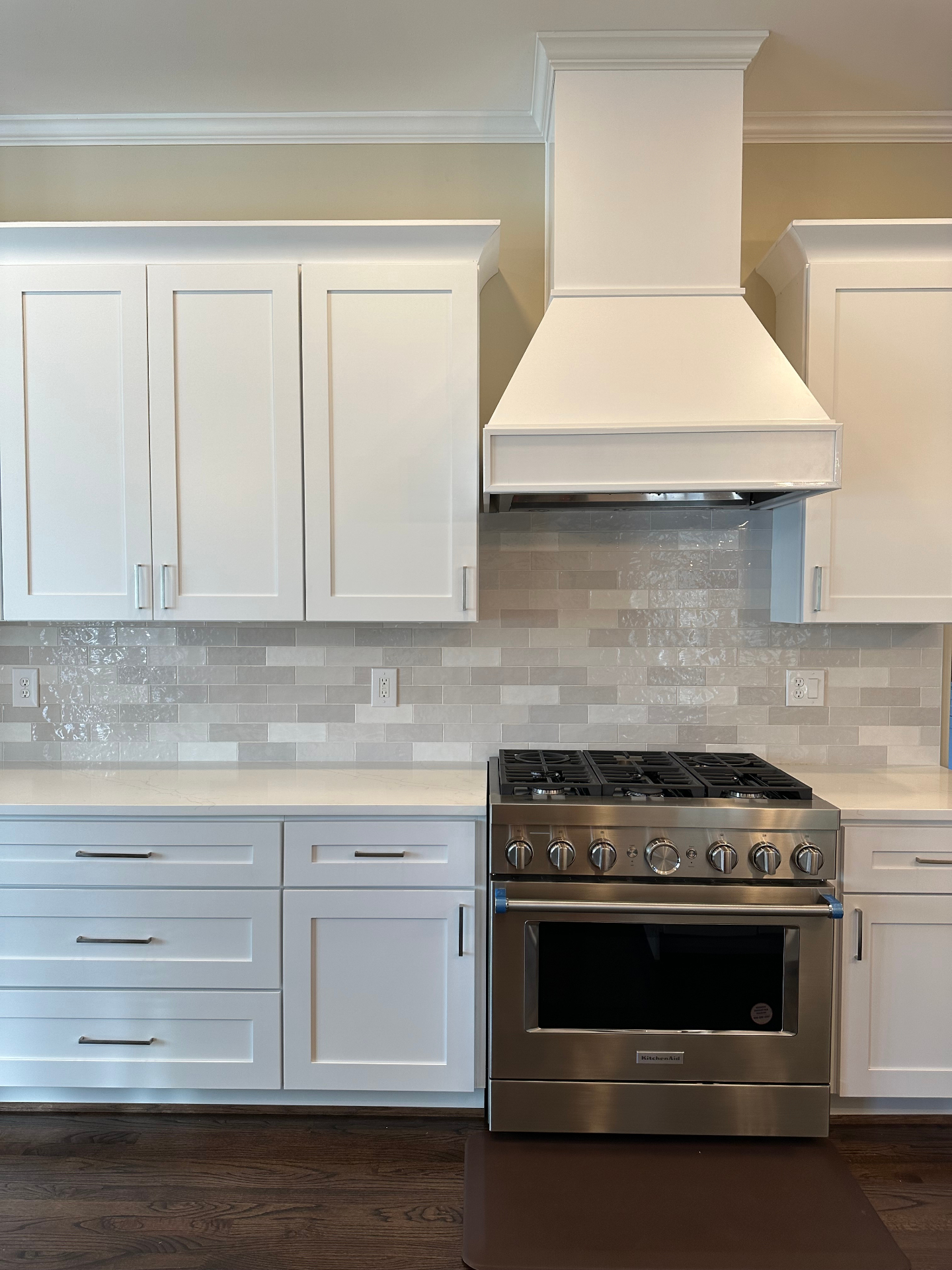 White shaker cabinets with custom hood and subway tile backsplash