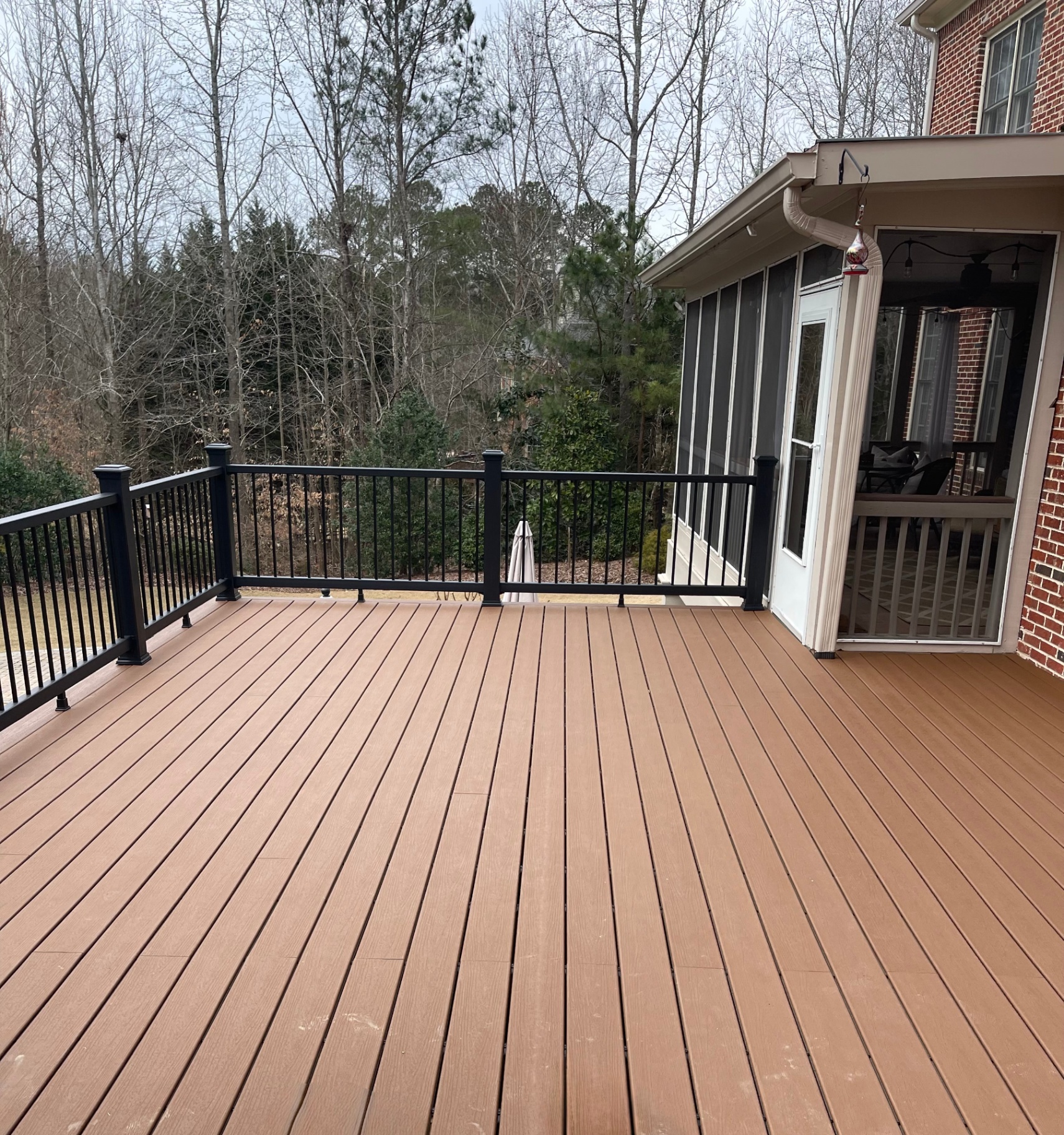 Spacious composite deck attached to brick home