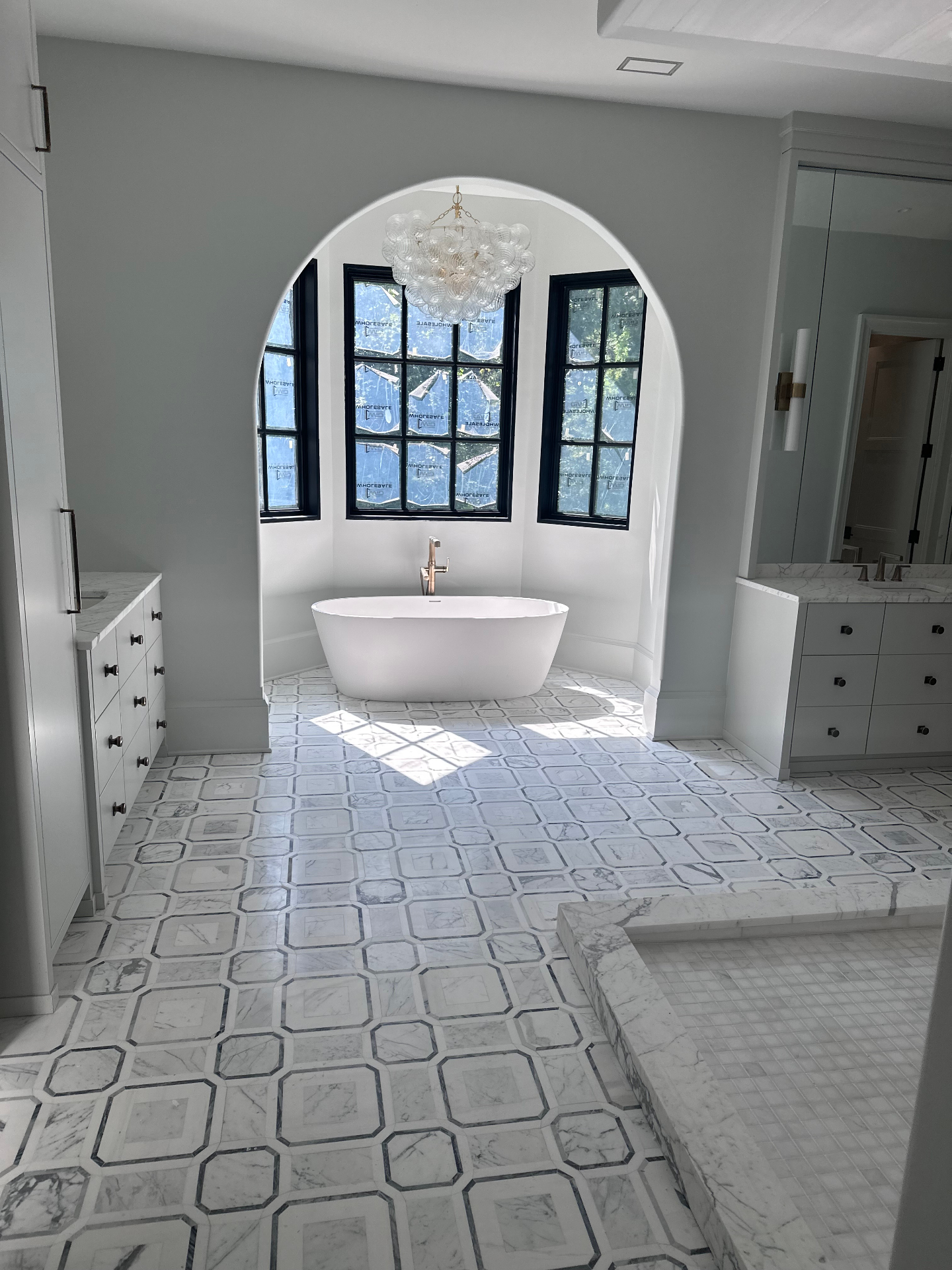 Spa-style bathroom with freestanding tub and arched opening