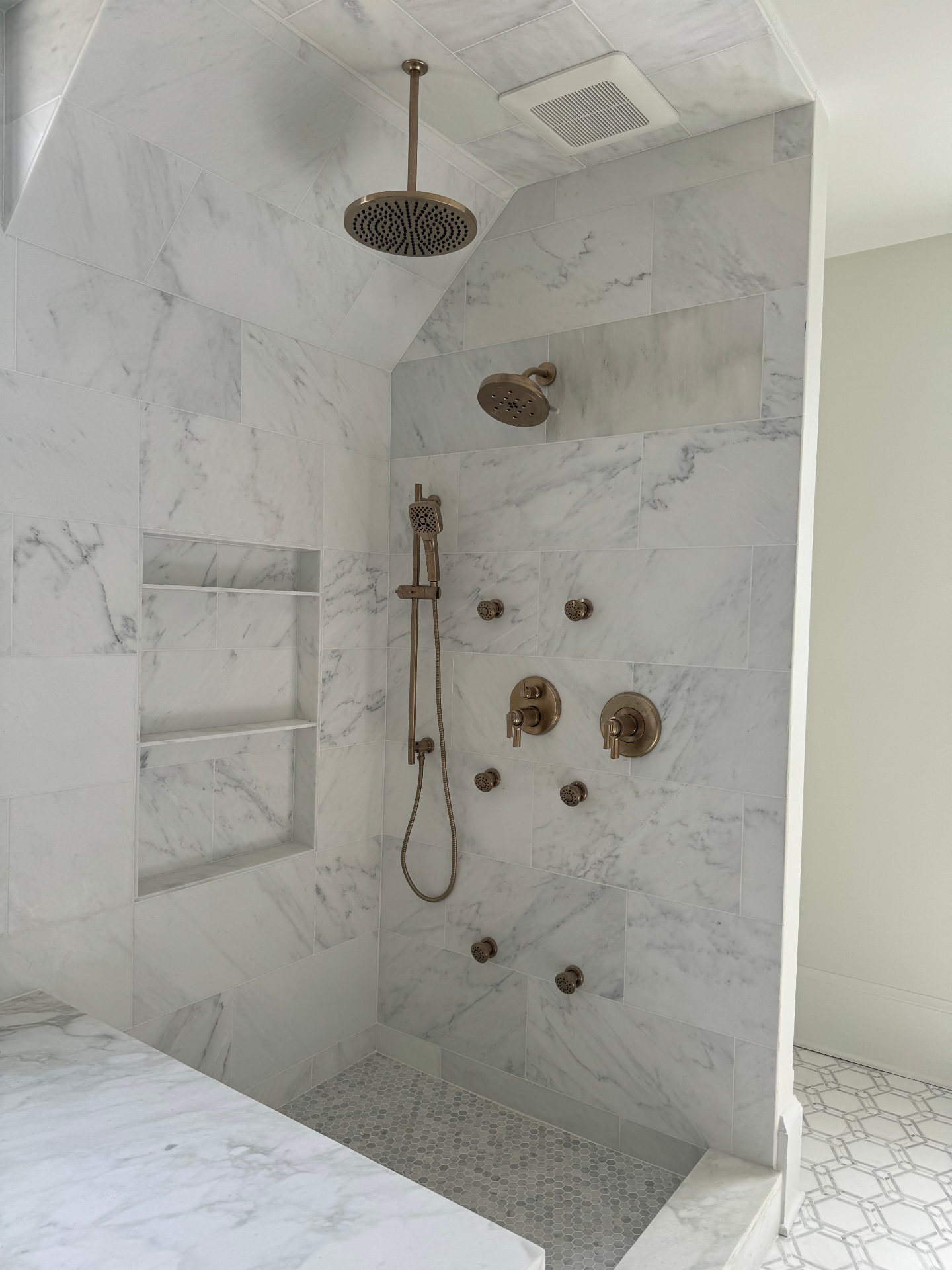 Marble shower with rain head, body sprays, and built-in niche