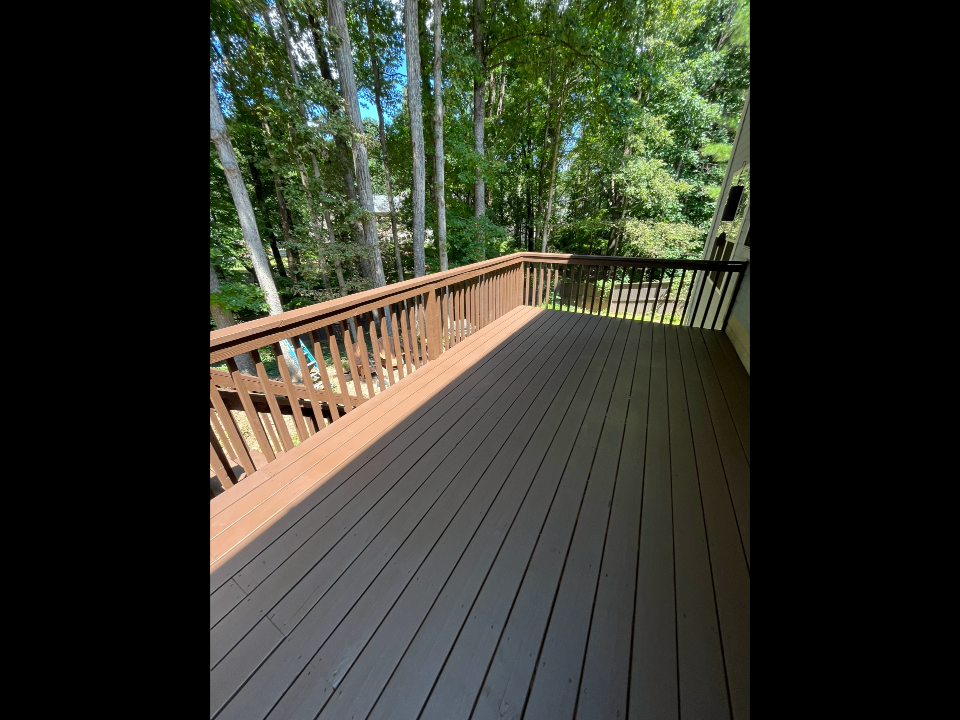 Refinished wood deck surrounded by trees